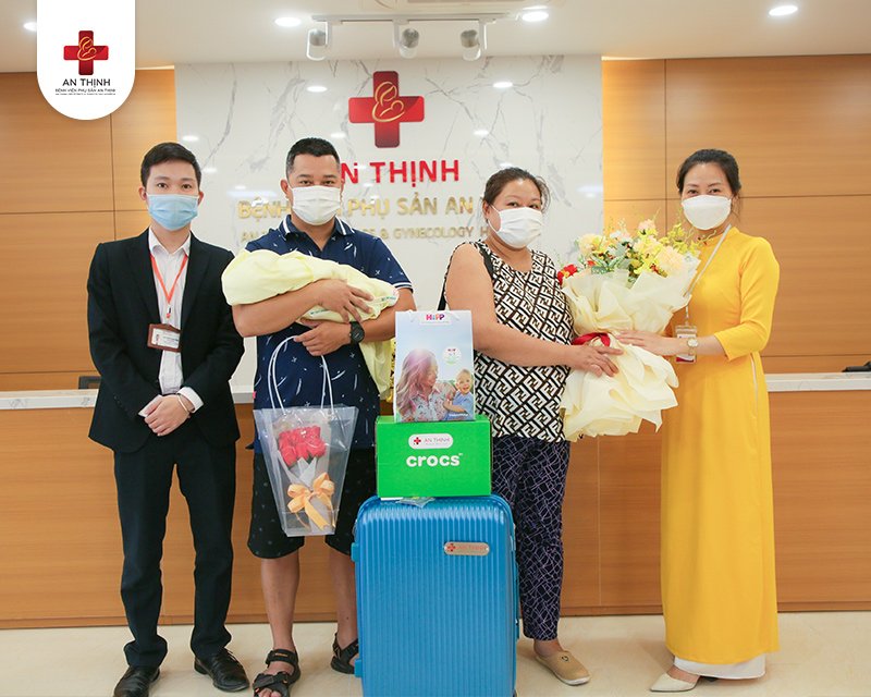 Nhân viên của bệnh viện gửi hoa và quà, cùng chụp ảnh lưu niệm với gia đình bệnh nhân sau khi kết thúc điều trị